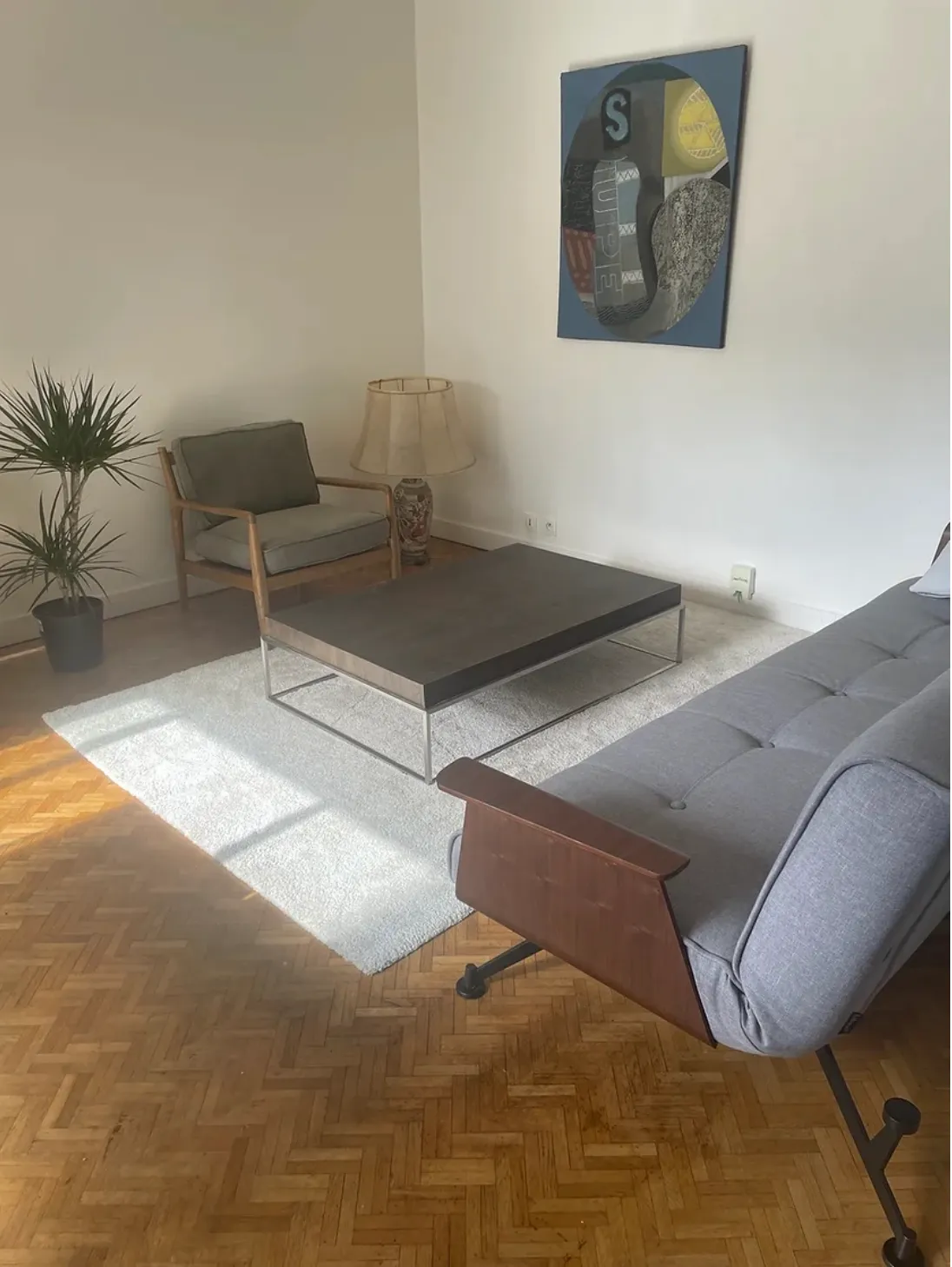 L’espace de consultation : canapé, fauteuil et table basse autour d’un tapis clair